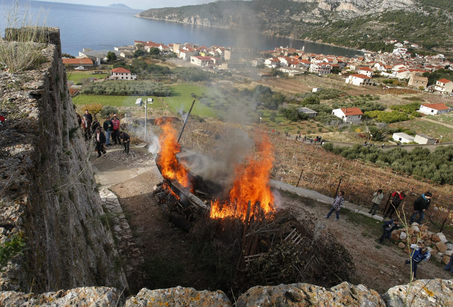 Komiza,01211. Komizani su i ove godine u prisutnosti mnogobrojnih gostiju,a u  skladu sa visestoljetnom tradicijom obiljezili blagdan sv. Nikole paljenjem broda.Sveti Nikola je zastitnik ribara, pomoraca i putnika i  slavi se kao dan grada. Obred spaljivanja staroga drvenog broda vrsi se na Musteru, ispred crkve sv. Nikole, a  pepeo se koristi za blagoslov novoizgradjenih brodova. Nakon rituala spaljivanja usljedila i procesija sa kipom sv.Nikole. Foto: Duje Klaric / CROPIX